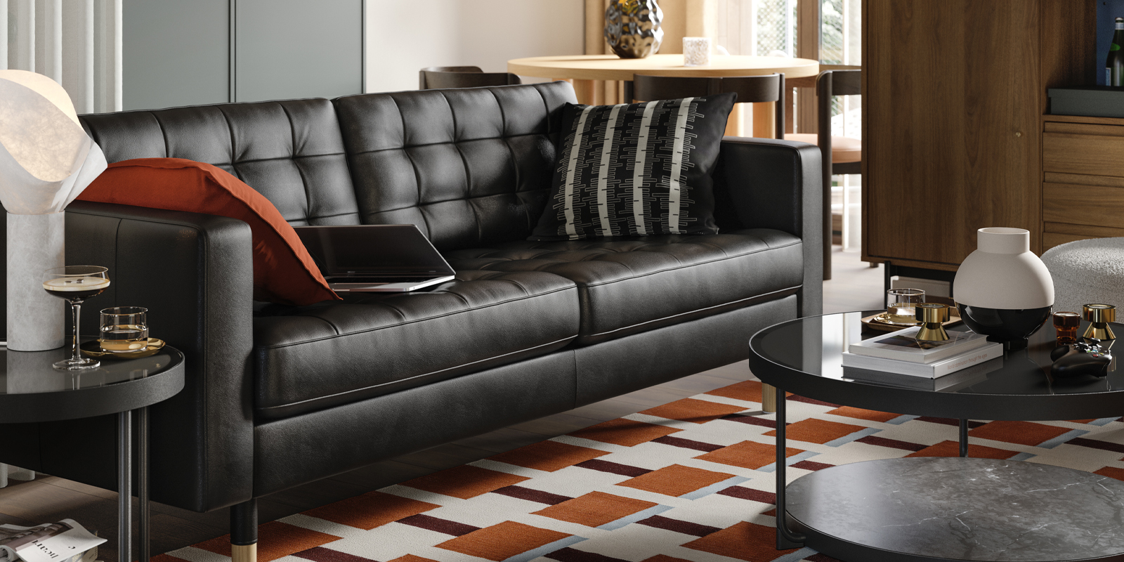 A leather and coated fabric 3-seat sofa stands in a living room near some BESTÅ storage and a RÅDMANSJÖ cabinet.